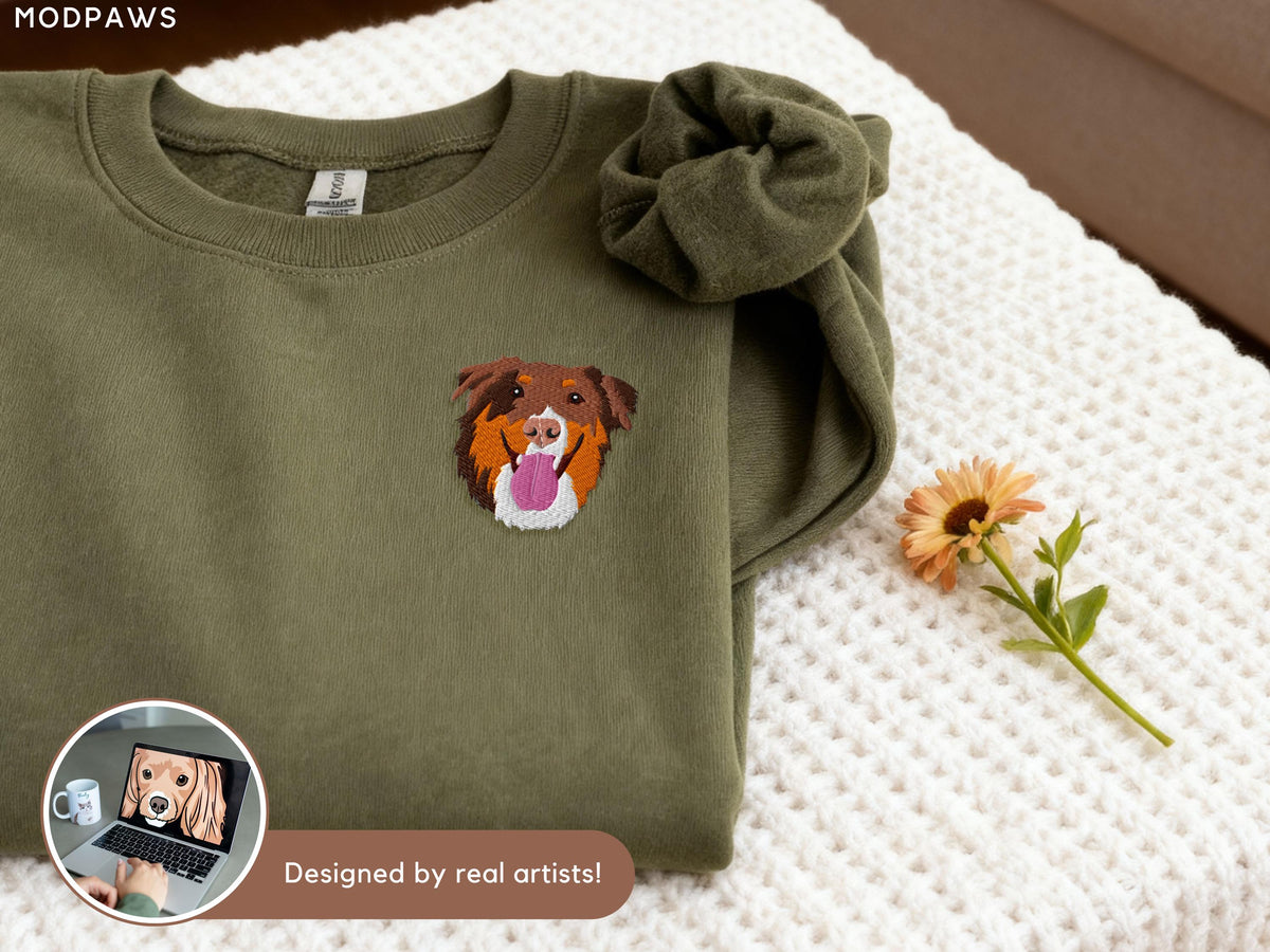 May include: An olive green crewneck sweatshirt featuring an embroidered patch of a brown, tan, and white dog face with a pink tongue sticking out. The text MODPAWS is visible in the top left corner, and a small inset shows a laptop screen.