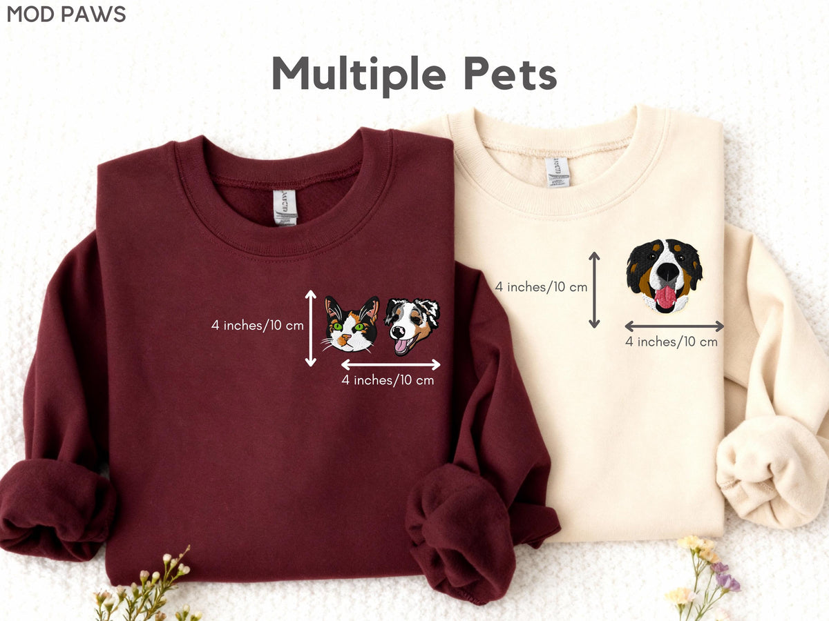May include: A maroon sweatshirt and a cream sweatshirt, each featuring a small embroidered pet portrait on the left chest. The maroon sweatshirt shows a cat and dog head, while the cream sweatshirt shows a dog head. Each graphic measures 4 inches.