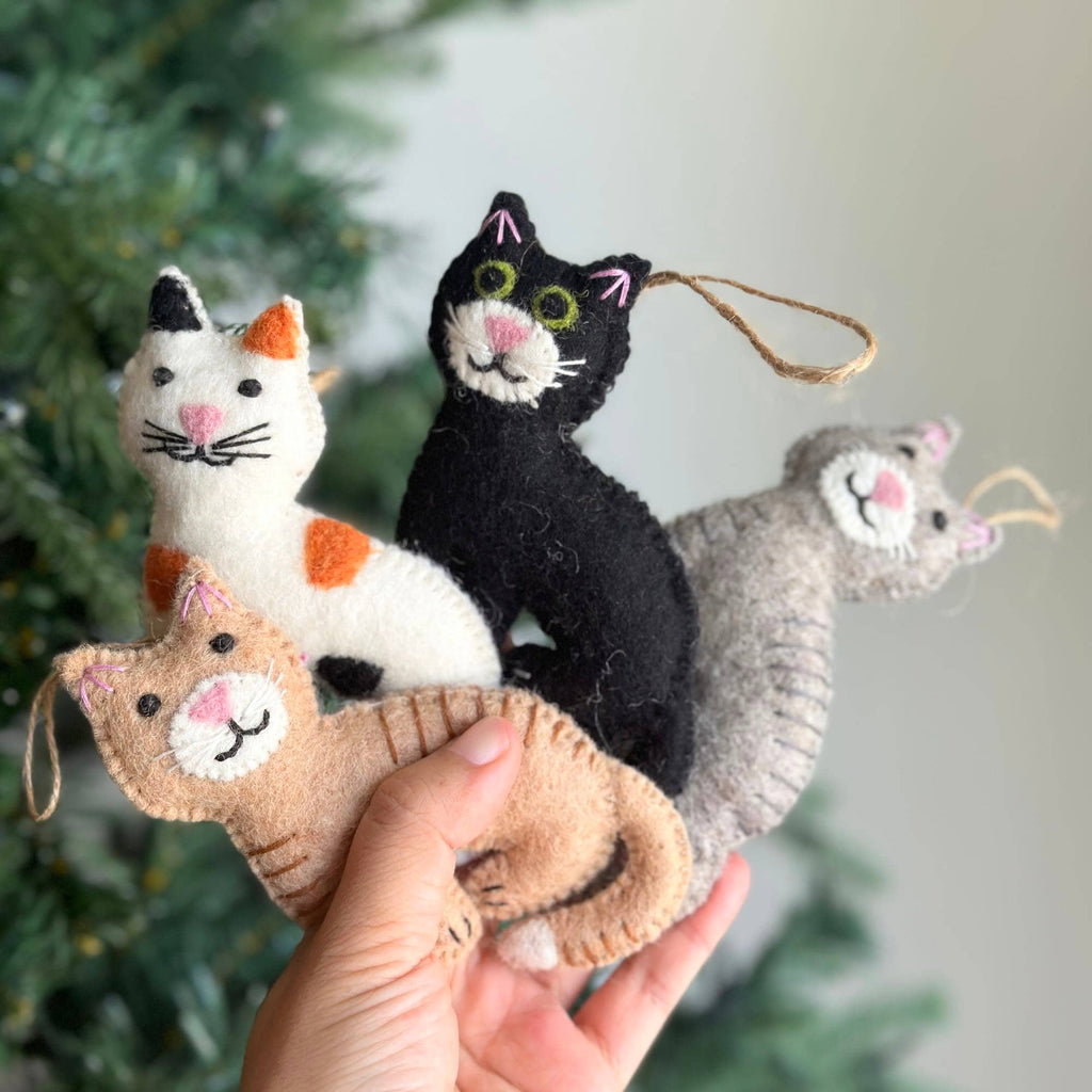May include: Four felt cat ornaments in different colors and patterns. The cats are all smiling and have embroidered details. The ornaments are perfect for adding a touch of whimsy to your Christmas tree.