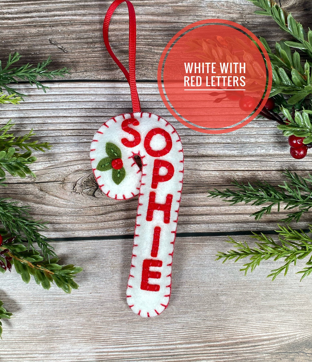May include: White felt candy cane ornament with the name "Sophie" stitched in red thread.
